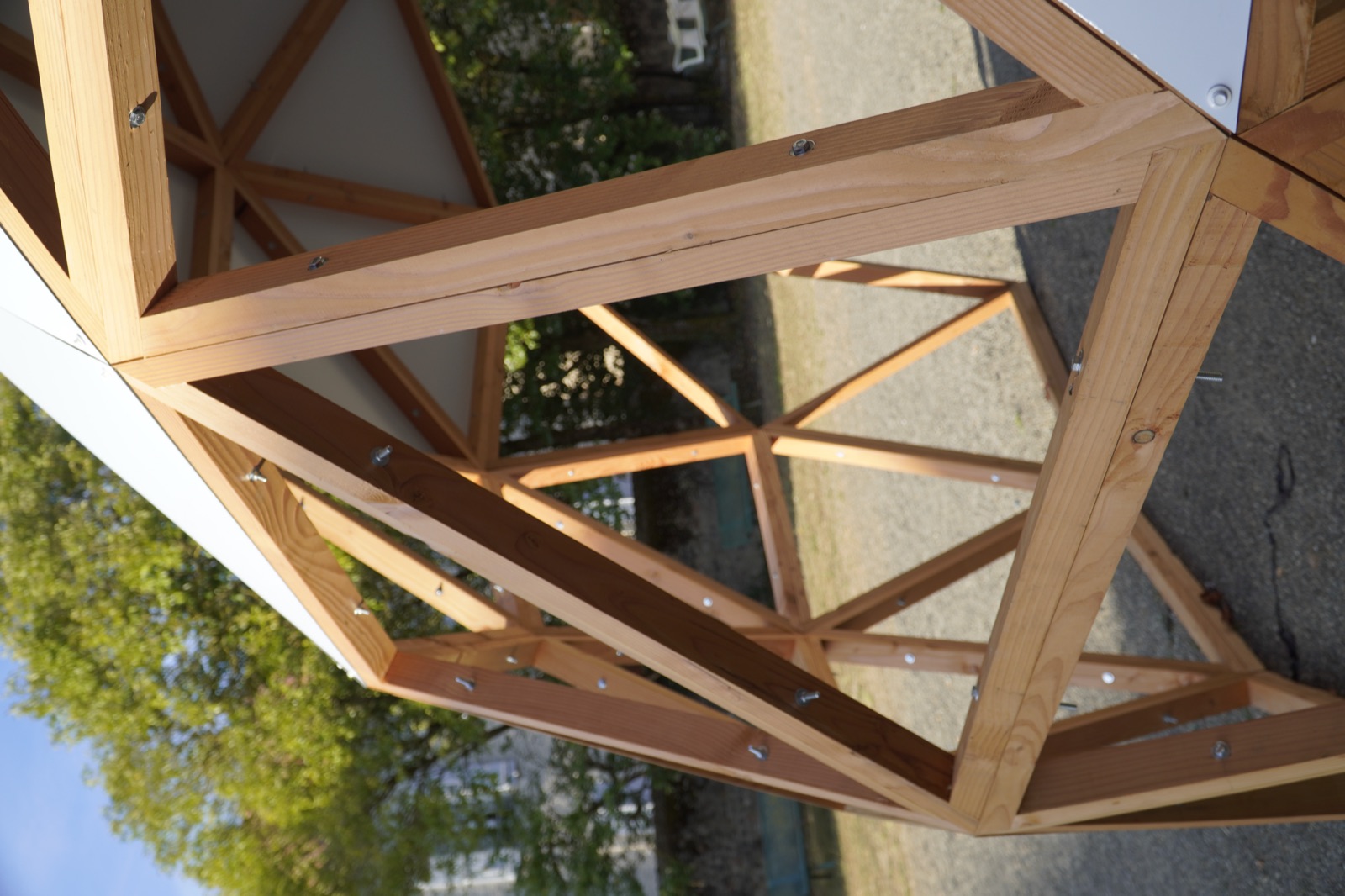 Détail de la charpente : triangles en bois massif, visserie apparente